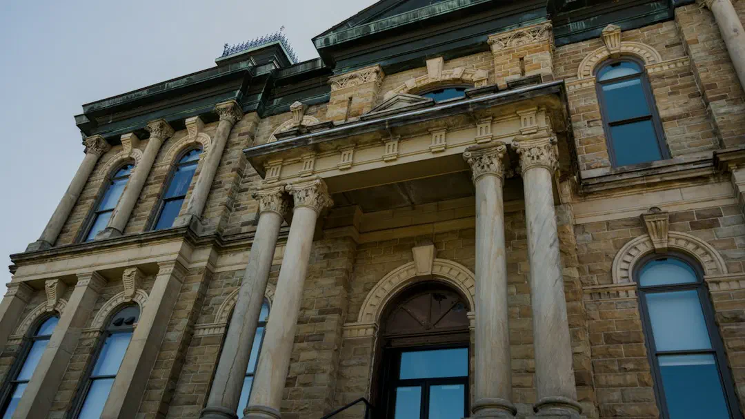 A stone building with arched windows and tall columns at its entrance