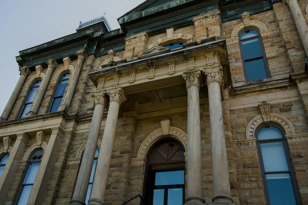 A stone building with arched windows and tall columns at its entrance