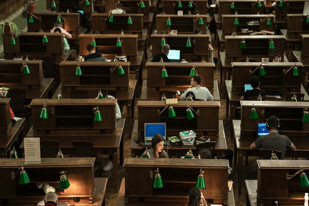 A room with rows of desks and computer screens