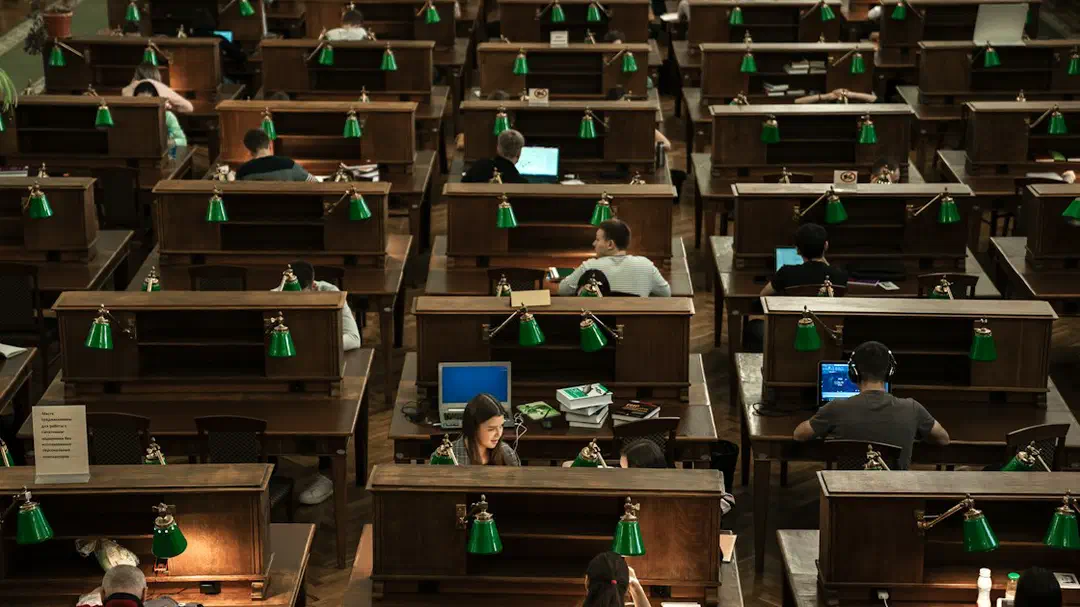 A room with rows of desks and computer screens