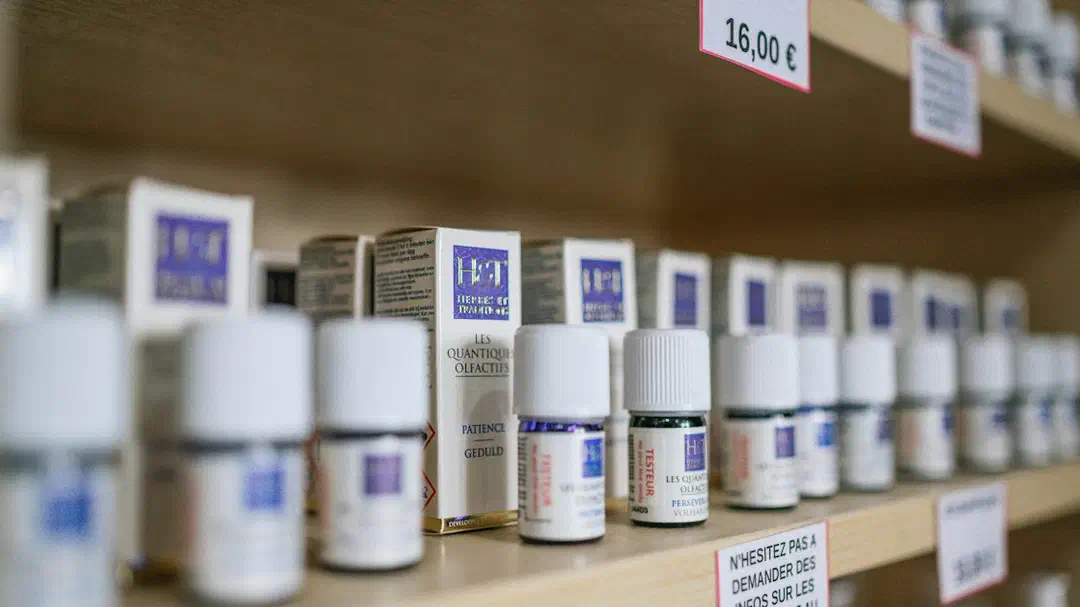 White plastic medicine bottles on a brown wooden shelf