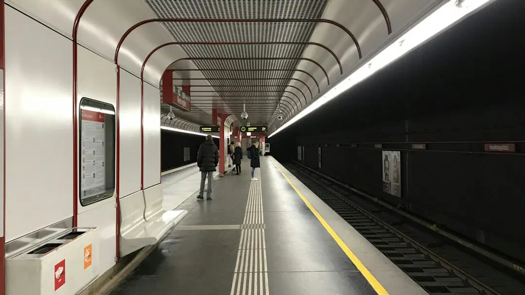 A red-lit tunnel along a metro train track