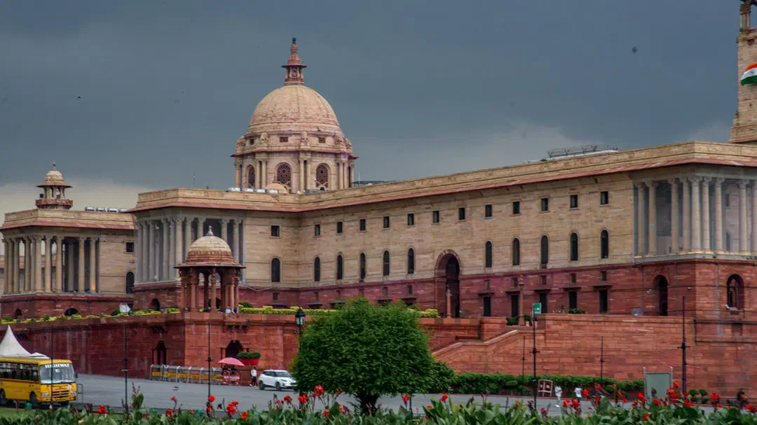 A grand sandstone building with columns and a dome