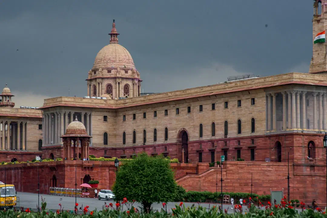 A grand sandstone building with columns and a dome